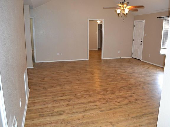 Living room with no furniture to show faux wood flooring