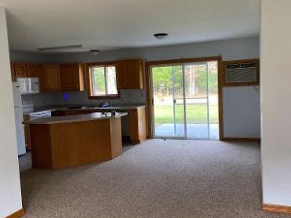 Kitchen - dining room view from living room. Shows patio and in wall AC unit. Drapes will be added to patio door.