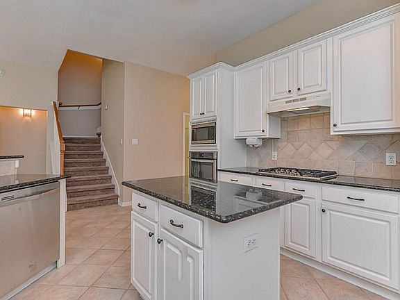 The kitchen is right of the stairs.