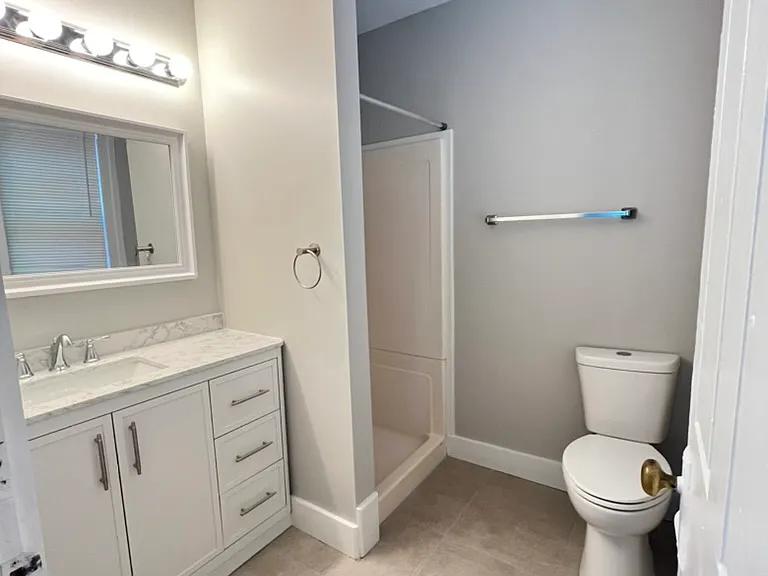 Updated bathroom with marble counters and tiled floor, new fixtures