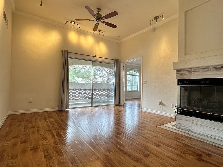 Relax in the spacious, high-ceiling living room, complete with a warm gas fireplace and cooling ceiling fan.