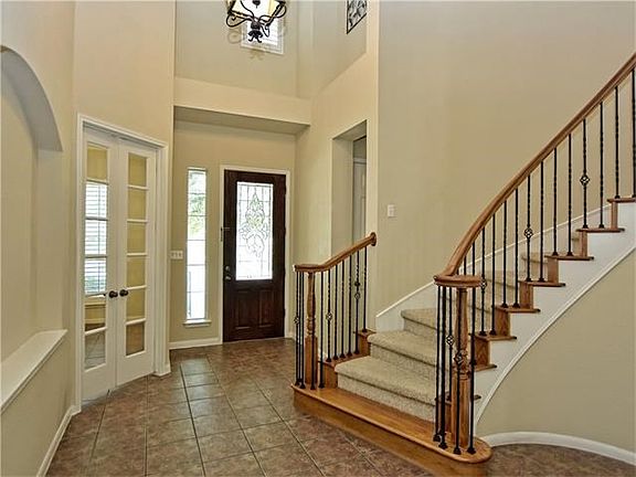 Foyer showing doors to study, staircase, and entry to half bath near front door.