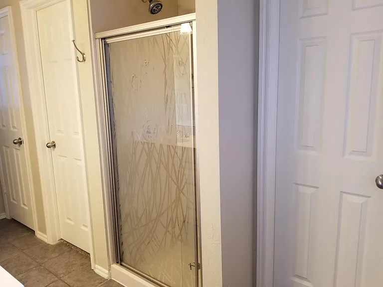 Master bathroom shower. Doors on each side of shower lead to large closet. Linen closet to the far left.
