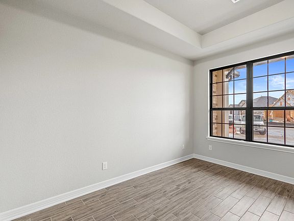 The home office features French doors, beautiful floors, large windows that give a fresh feel, this
