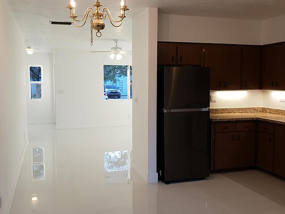 A view of the entrance, living room, dining area and kitchen.