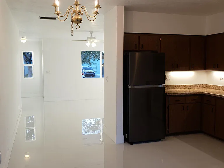 A view of the entrance, living room, dining area and kitchen.