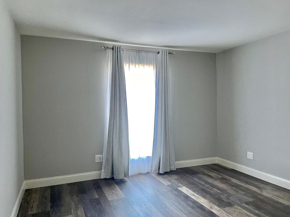 Bedroom has great natural light, plank flooring, and warm, neutral grey wall paint scheme. Plenty of wall space and the area accommodates most furniture easily.
