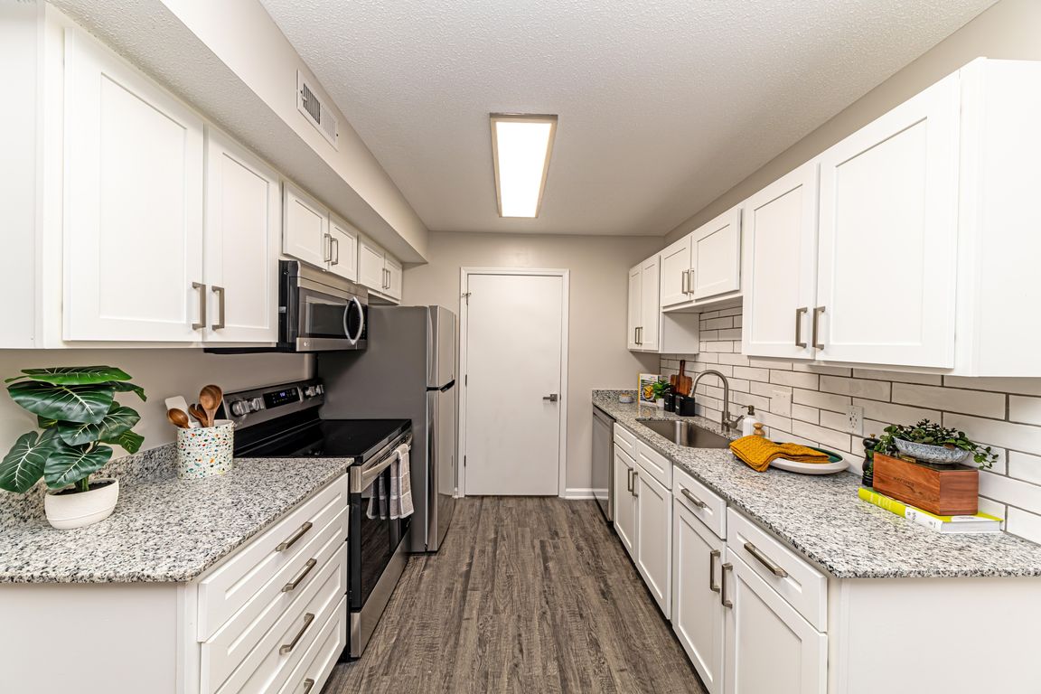 Kitchen with granite counters, modern cabinetry, and stainless steel appliances