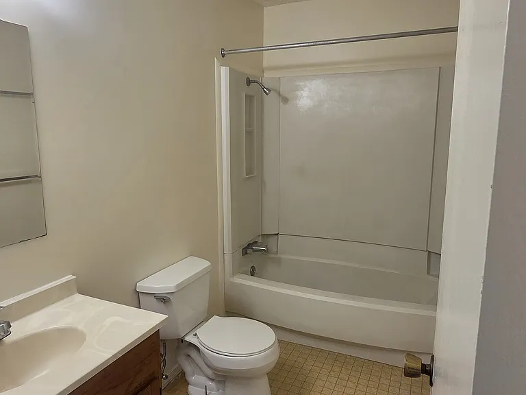 Full bathroom with tub/shower combo, freshly painted walls, wood vanity with ample storage, and a built-in shower niche.