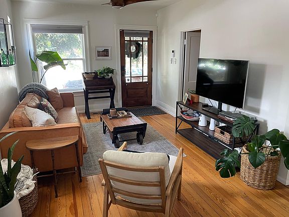 Living room with view to front door and office/guest bedroom door.