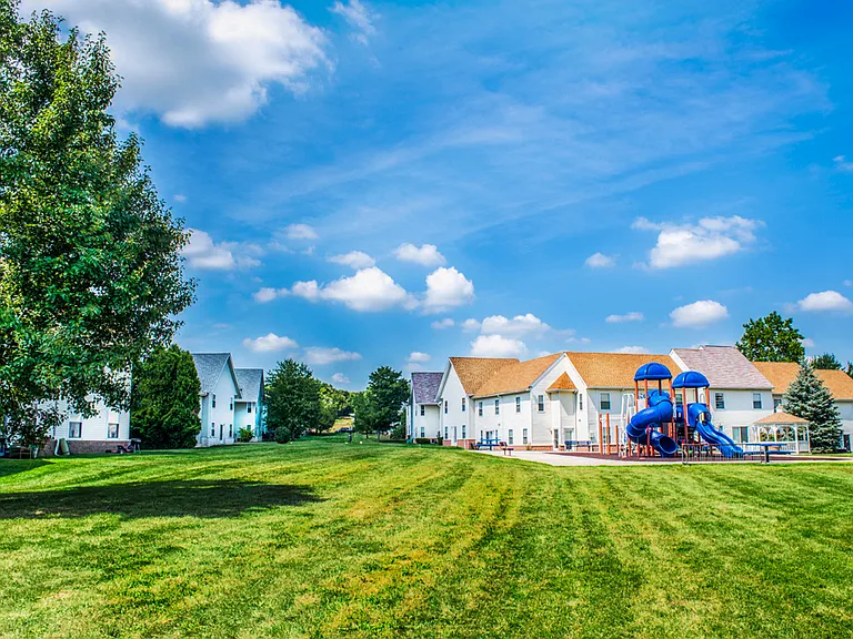Live with open skies, green grass, and playground amenities