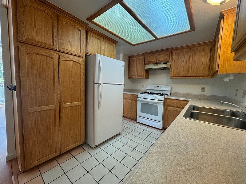 Kitchen with refrigerator, tile floors
