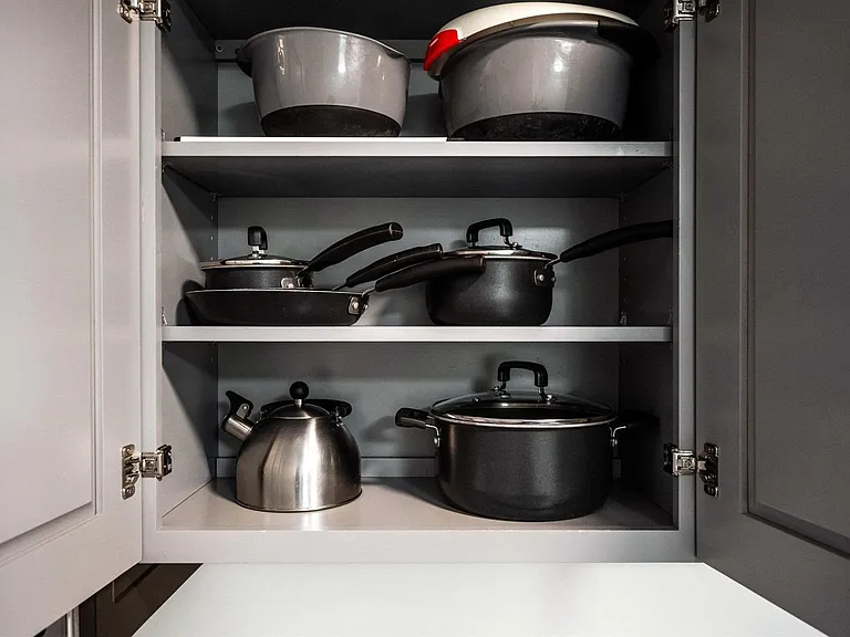 Organized kitchen cabinet storage with shelves for cookware and meal-prep essentials, keeping the kitchen tidy and functional