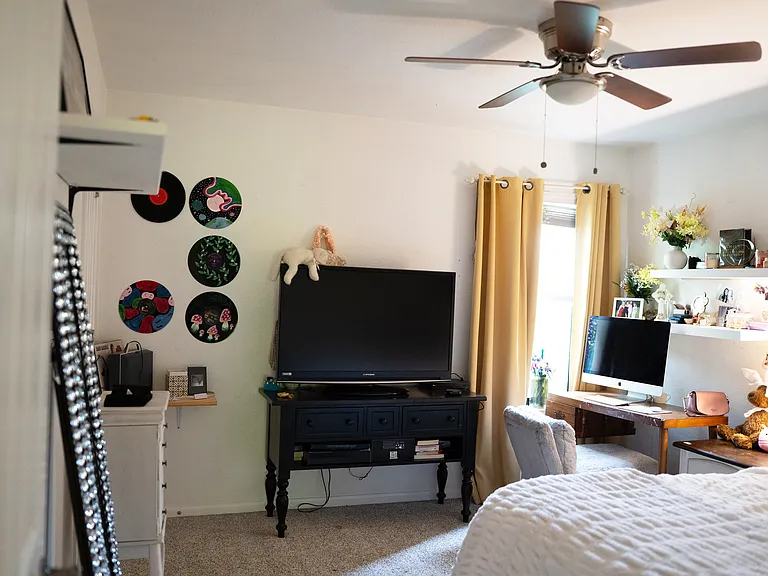 Second bedroom with walk-in closet, window lets in natural light but trees outside provide privacy and shade.