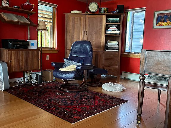 The den portion of the living room with the piano