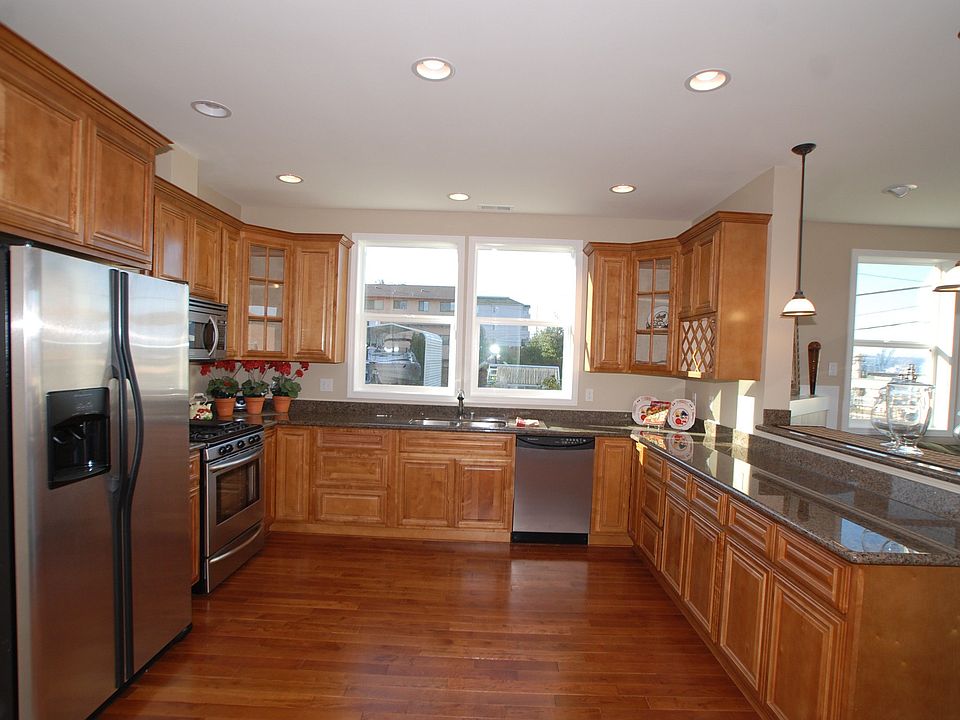 Gourmet kitchen with stainless steel appliances, hardwoods, granite & view
