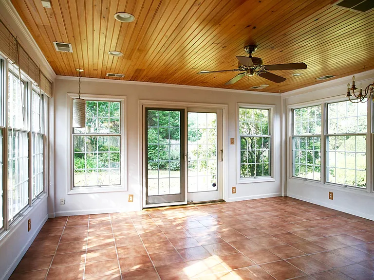 Windows all around in sun room and sliding glass doors open into the backyard