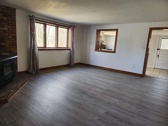 Living room with large window and wood burning stove.