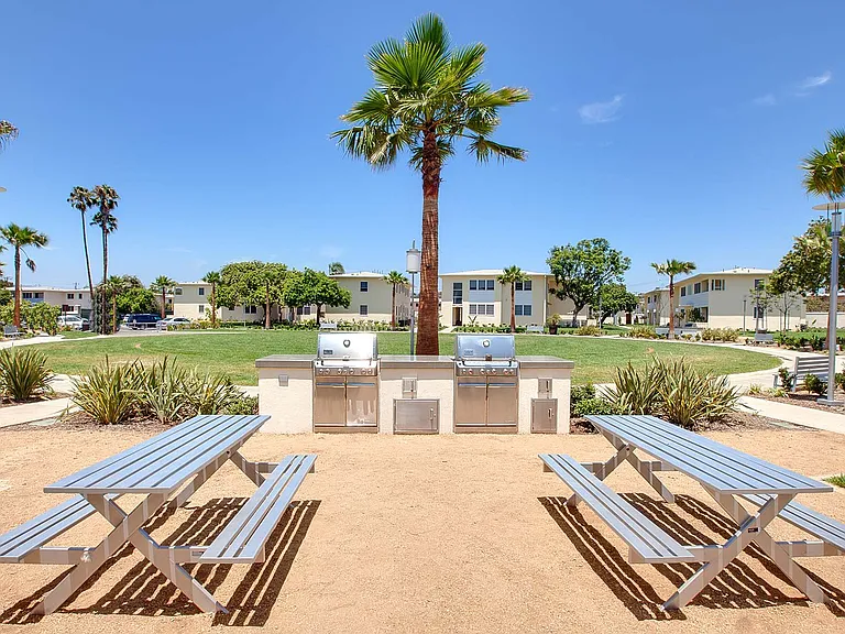 Barbecue area with picnic tables and stainless steel grills at Elkgrove Circle