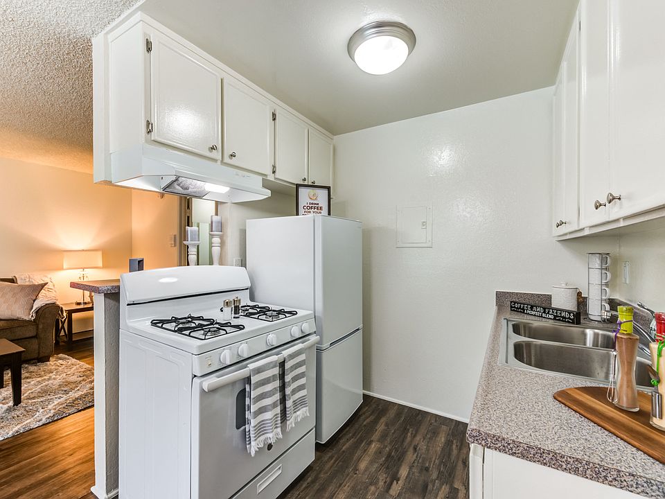 Specious open concept kitchen with appliances and plank flooring at the Promenade Apartment in Van Nuys, CA