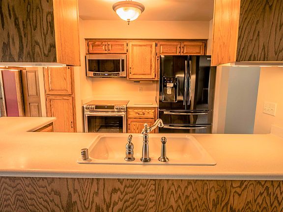 Open kitchen with new stainless steel appliances.