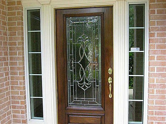 Mahogany front door with leaded glass inserts and tiled front entry porch.