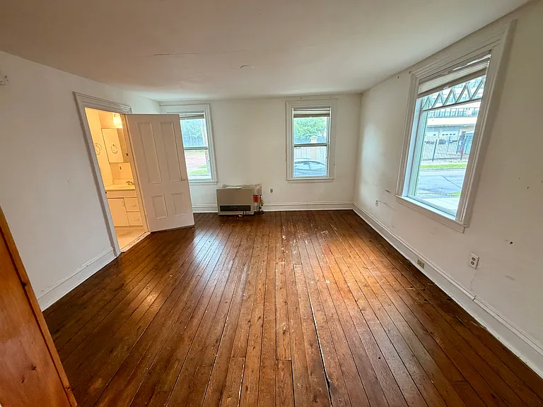 Inside bedroom/living area space. Bathroom to the left.