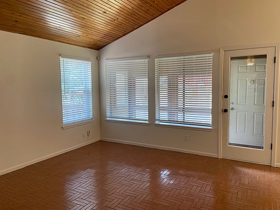 Living room with vaulted ceilings and tile floors looks into the greenhouse.