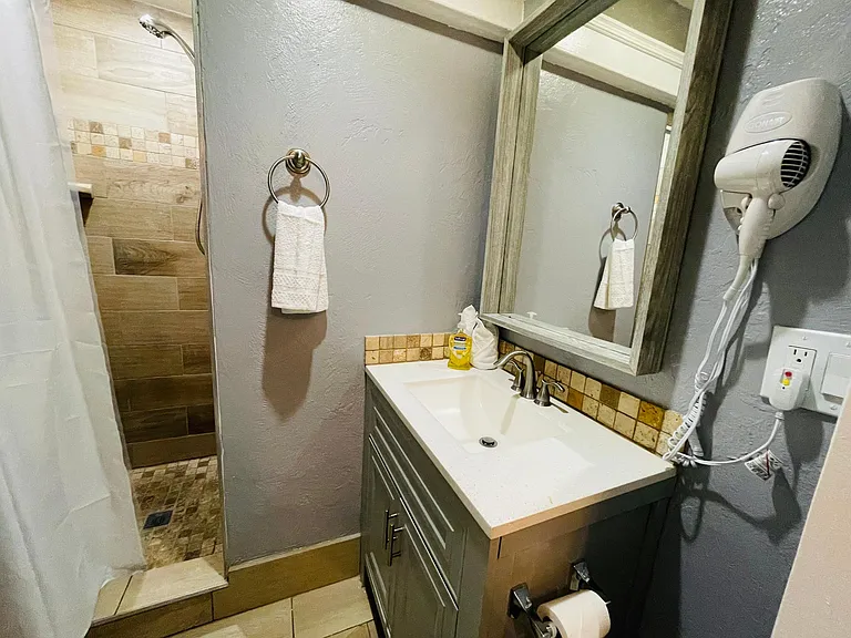 Bathroom with Shower, toilet and sink, towels and hairdryer