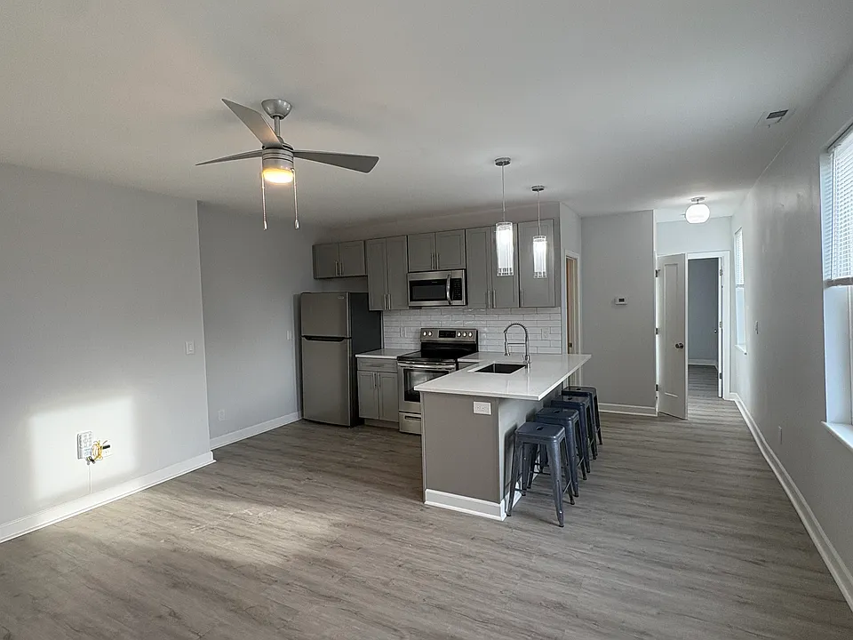 Gleaming kitchen featuring stainless steel refrigerator, oven, microwave, and dishwasher. Quartz countertops