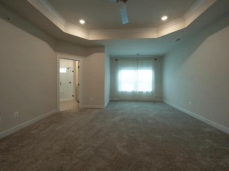 Large Owner's Bedroom features tray ceiling, TWO walk-in closets (one is a huge 12.5' x 6.5'), en suite bathroom, and smart ceiling fan