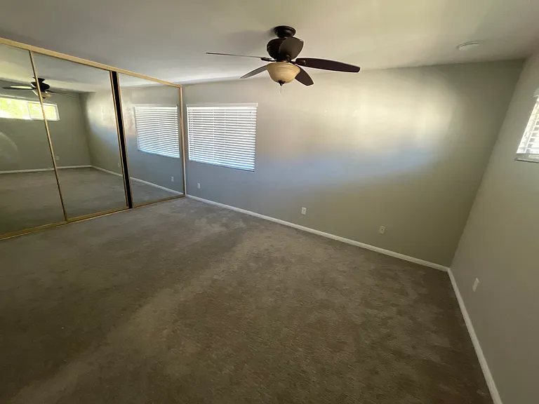 Master bedroom with remote powered ceiling fan and 3 mirrored door closet with a private master bathroom