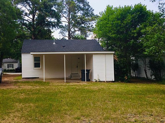 The spacious backyard has private parking with an attached carport.