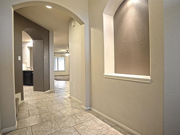 Entry with art niche, arched doorways and extensive tile!