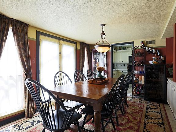 The formal dining space has double doors that lead out to a wonderful deck that wraps around a large area of the house and makes it perfect for outdoor entertaining.