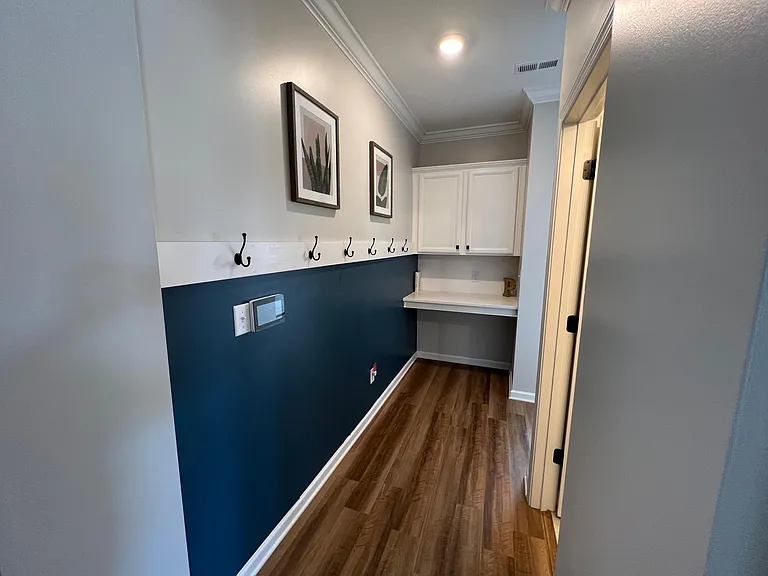 Hallway entrance from garage with desk and storage cabinets