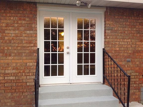 French doors leading to a patio unto a large privacy fenced yard.