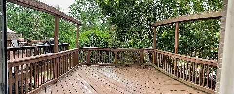 Deck off main level kitchen and living room above patio facing tree line
