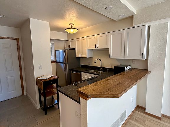 Open kitchen with breakfast counter overlooking living room