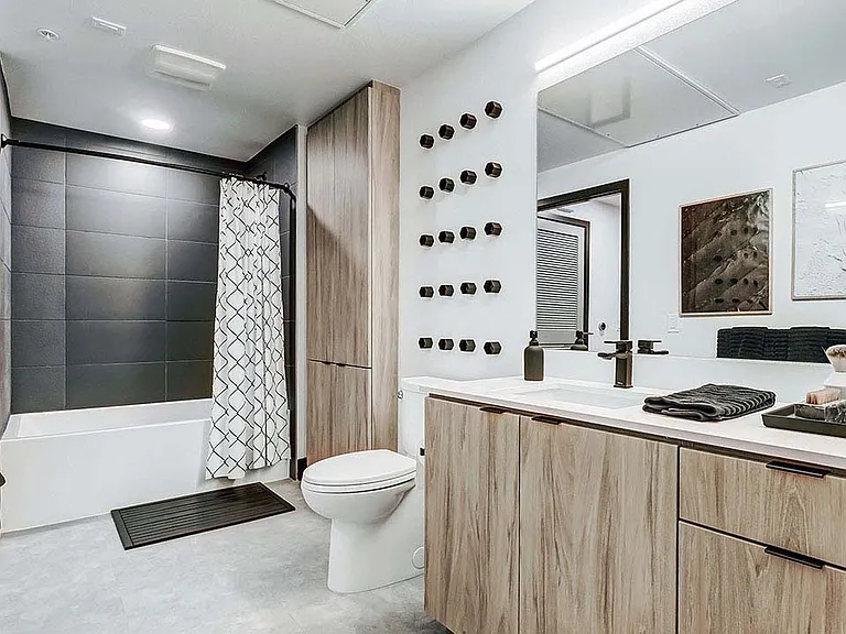Griffis Platinum Triangle apartment bathroom with tiled shower tub and quartz countertops.
