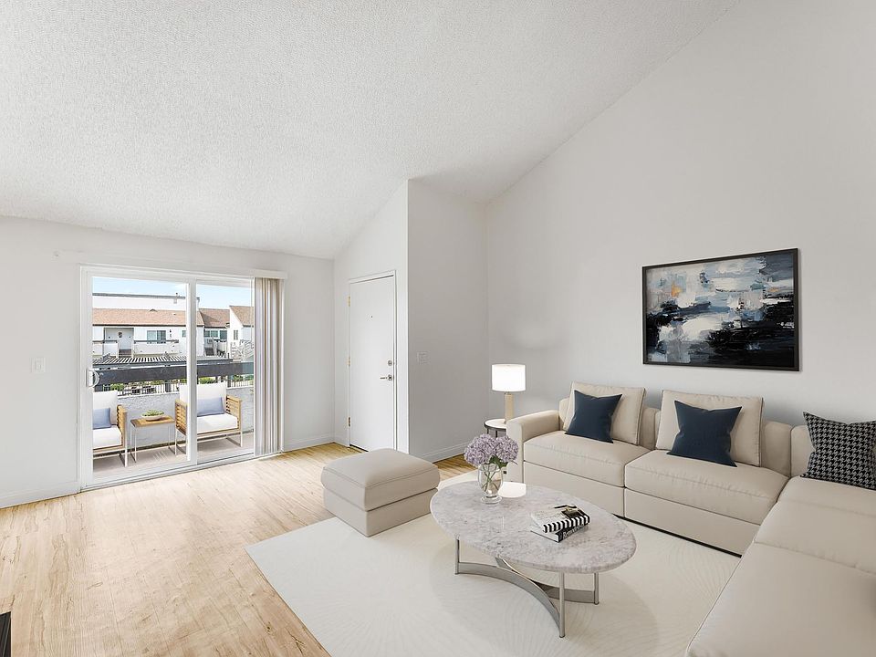Living room with vaulted ceilings leads to the balcony.