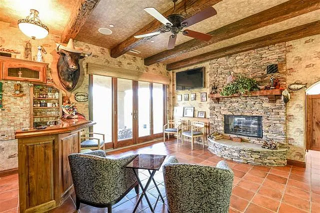 Man cave with Bar, fireplace, and sliding doors with full view of valley