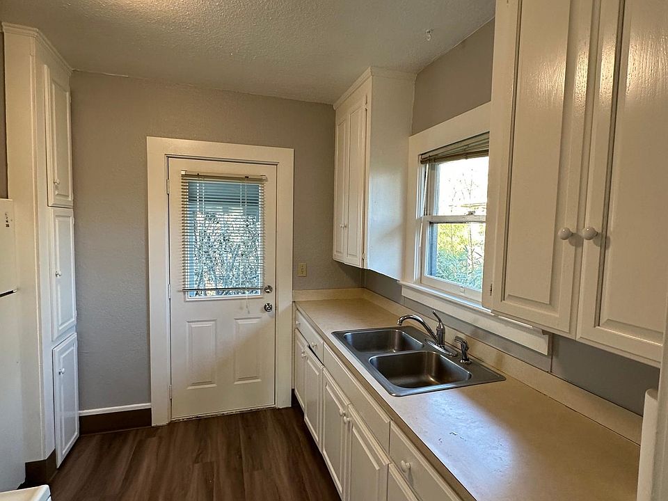 Kitchen. View is to back door and stairs to shared-use patio.