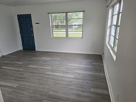 House entrance door and Living Room with two windows. New flooring and recently painted.