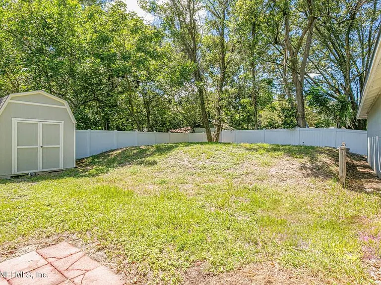 Fenced back yard with storage shed.