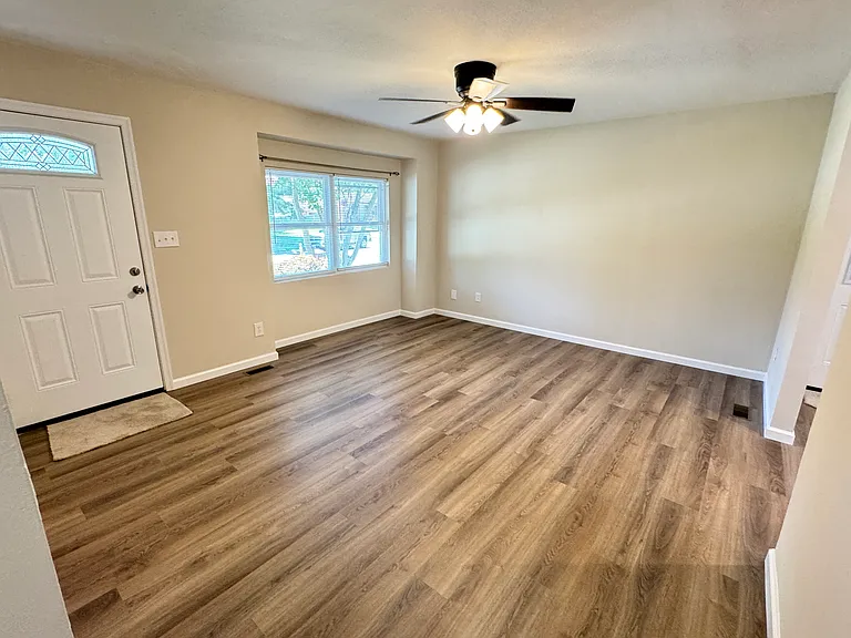 Living room. Front door is on the left, opening to the kitchen is on the right.