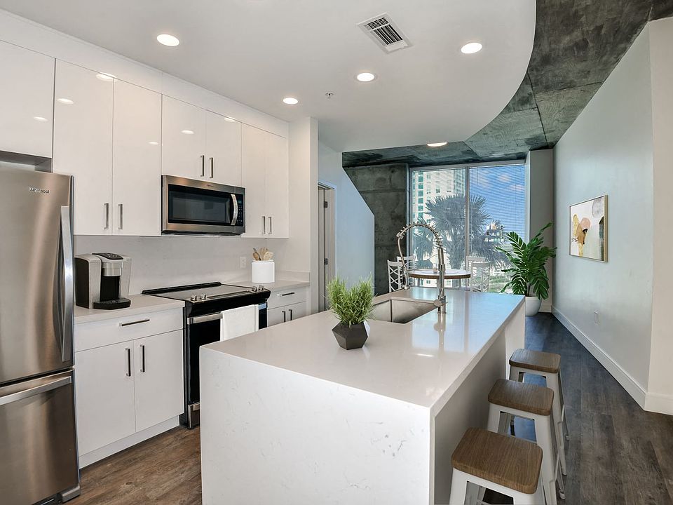 Kitchen with white cabinets, white quartz countertops, and stainless steel appliances