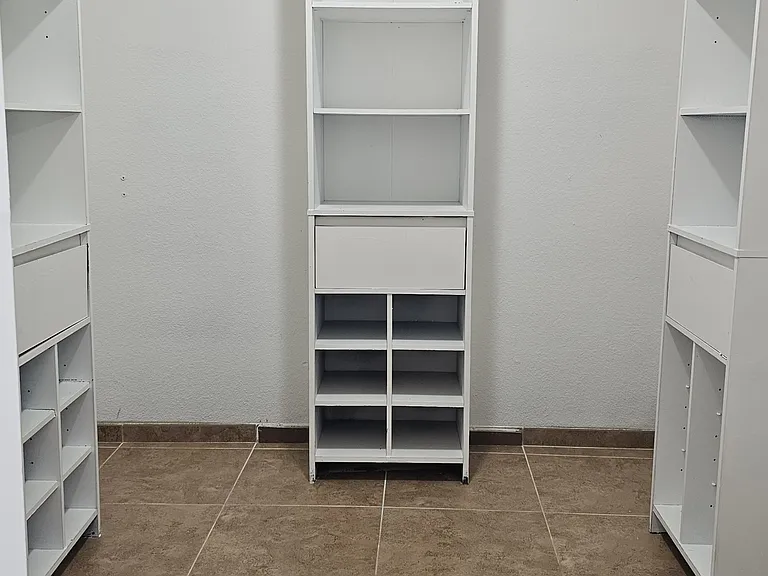 Well designed walk-in closet in the primary bedroom featuring built-in shelving and generous storage space.