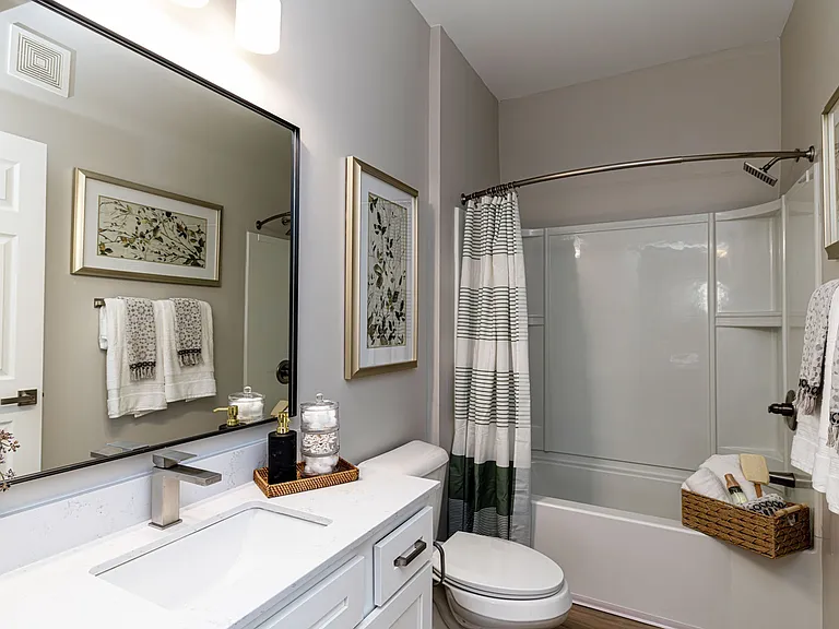 Bright bathroom with quartz counters, high-rise faucets & bathtub