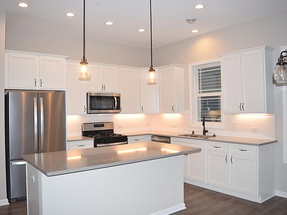 Chef's kitchen with quartz countertops, stainless steel appliances, pull out cabinets with soft close doors.